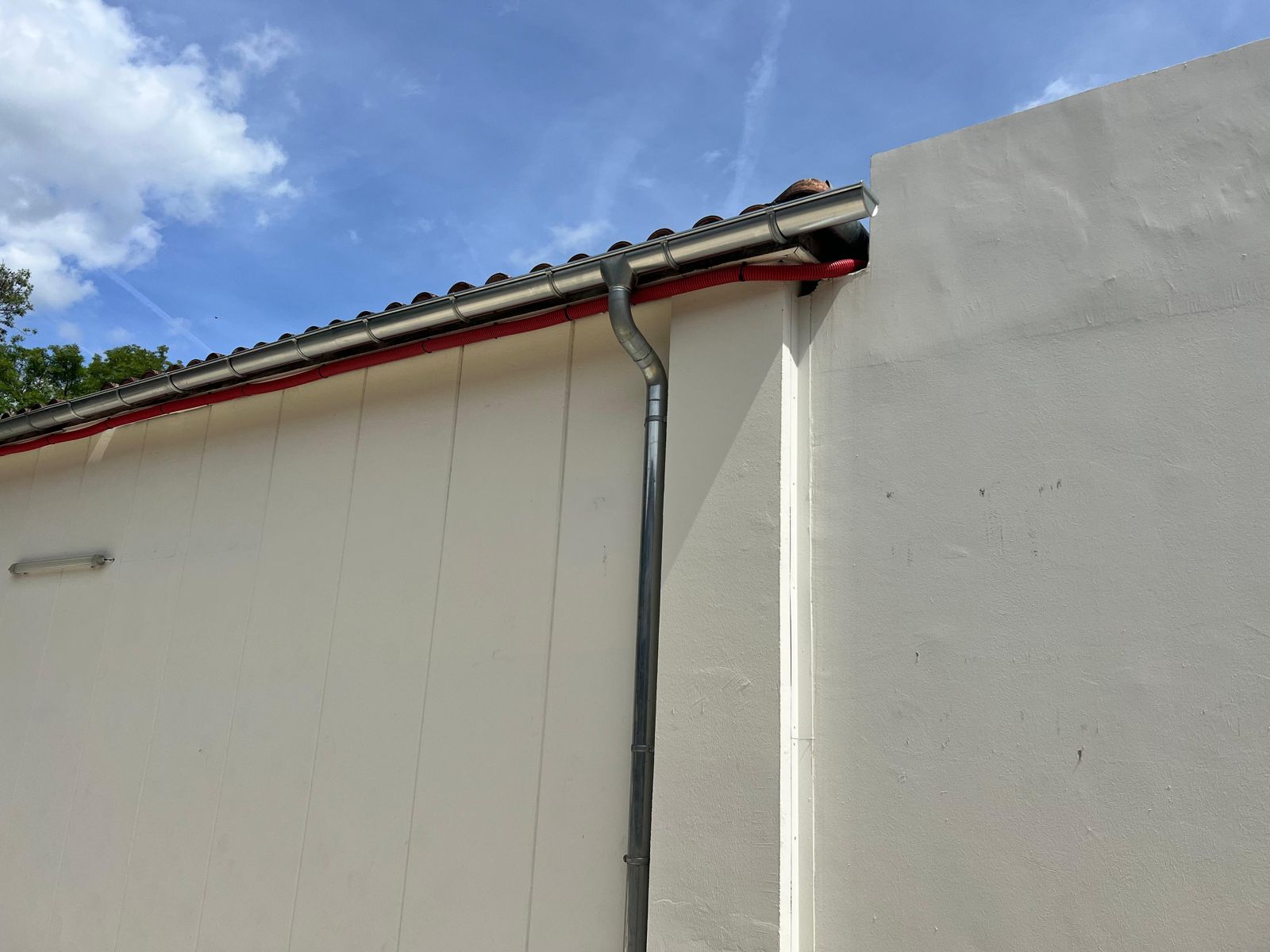 Gouttière et descente d’eaux pluviales sur une façade