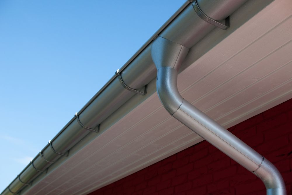 Gouttière et descente en aluminium sous un débord de toit