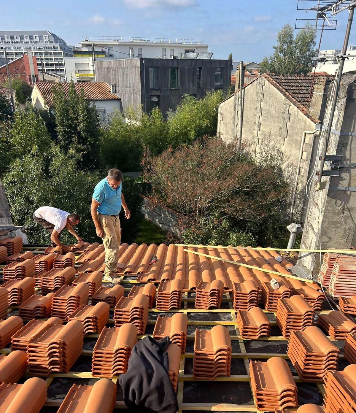 Équipe de couvreurs posant des tuiles neuves sur des liteaux